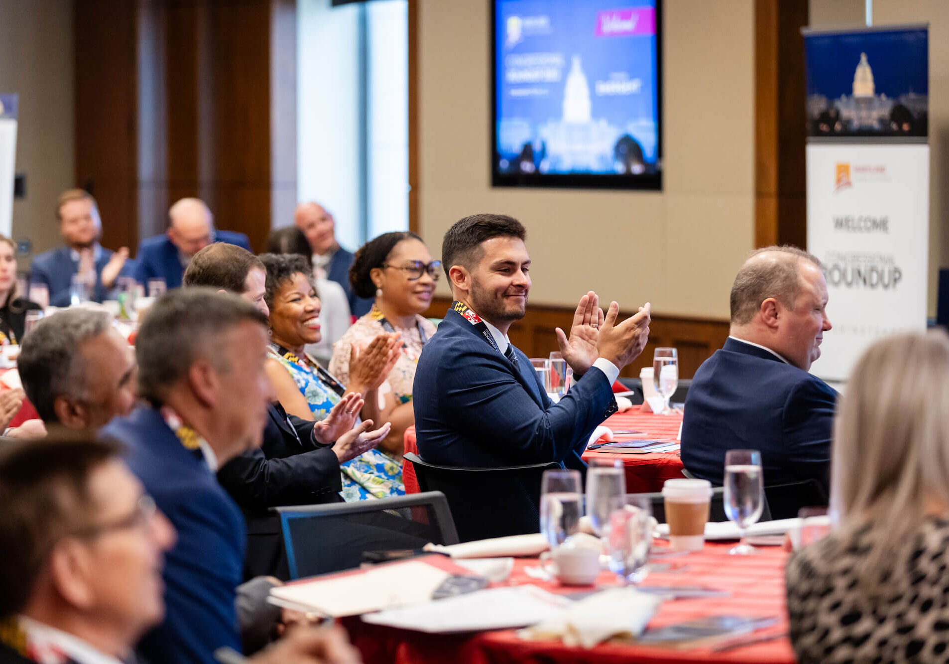 Audience members attending the Maryland Chamber of Commerce's Congressional Roundup Event look on from their seats and applaud a speaker.